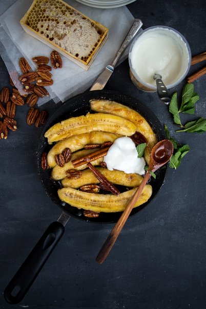 Medu karamelizeti banani ar kaneli un pekanriekstiem pasniegti ar bezpiedevu jogurtu